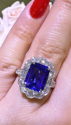 a woman's hand with a ring on it and a blue stone in the middle