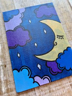 a painting on wood with clouds and a moon in the night sky above it is a wooden floor