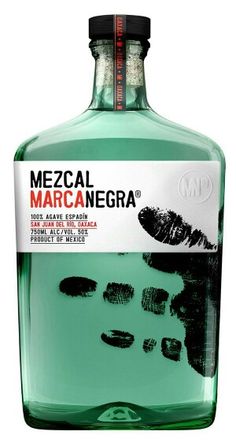 a bottle of mezcal manoegra with black ink on the bottom and inside