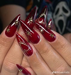 a woman's hand with red and gold stiled nails