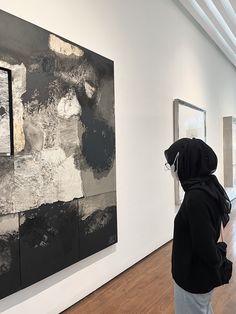 a woman looking at artwork in an art gallery