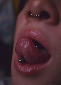 a woman with piercings on her nose and tongue