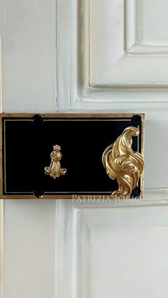 a black and gold door handle on a white door