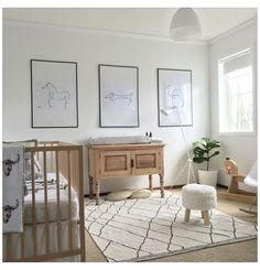 a baby's room with white walls and pictures on the wall