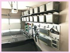 a car parked in a garage with lots of storage containers on the wall above it