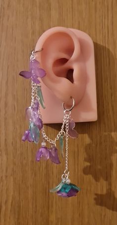 Introducing our gorgeous handmade butterfly and rose earrings. These are available in purple, red and pink, with the choice of helix and earring or if you wish just dangle earrings. These butterfly designs are intricately sculpted, capturing the ethereal essence of these enchanting creatures with wings poised in mid-flight, accentuated by subtle, shimmering details that catch the light with every movement. Complementing the butterflies, the rose motifs are artfully shaped, showcasing the intrica Butterfly And Rose, Ethereal Essence, Earring Chain, Butterfly Designs, Handmade Butterfly, Boys Jewelry, Earring Designs, Magical Jewelry, Purple Earrings