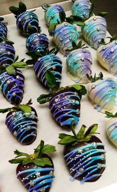 chocolate covered strawberries with blue and white frosting on them are arranged in rows