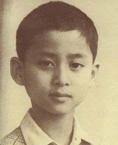 an old black and white photo of a young boy wearing a sweater with a tie