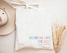 a white bag sitting on top of a bed next to a hat