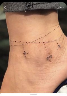 Feminine Mom Tattoos, States Tattoo Ideas, Simple Line Tattoos Minimalist, Ankle Charm Tattoo, Places To Tattoo A Name, Anklet Tattoos For Women Unique, Unique Tattoos For Moms With Kids, Dainty Tattoos For Moms With Kids, Cute Ankle Tattoos For Women