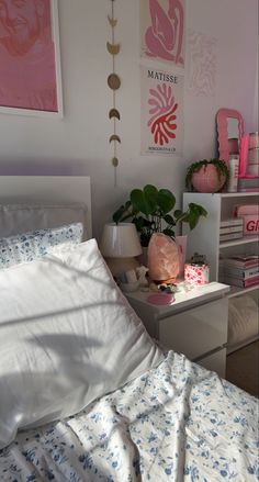 a bedroom with pink and white decor on the walls, bed linens and pillows