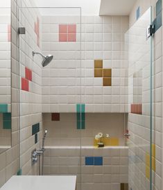 a bathroom with colorful tiles on the walls and floor, along with a bathtub