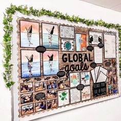 a bulletin board with many pictures on it and plants growing up the wall behind it