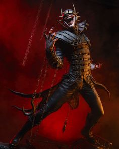 a statue of a demon with horns and chains