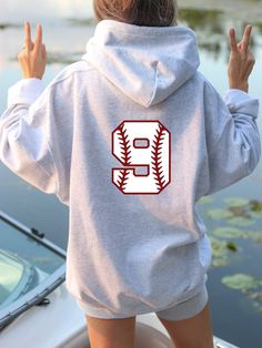 a person wearing a hoodie with the number nine on it and holding their hands up