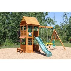 a wooden swing set with a green slide