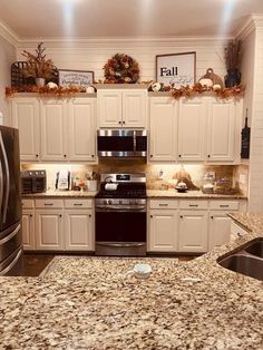 a kitchen with granite counter tops and white cabinets