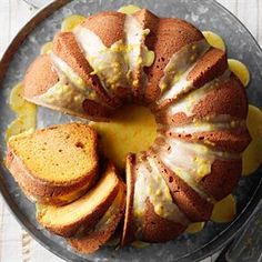 a bundt cake with lemon glaze and sliced slices on a glass platter