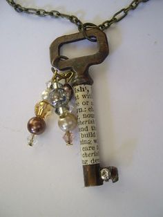 an old key is attached to a chain with beads and charms hanging from it's end