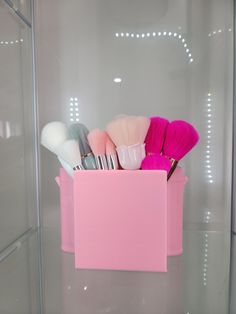 a pink container filled with lots of makeup brushes