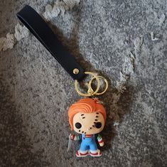 a keychain with a cartoon character on it is laying on the ground next to a pair of scissors