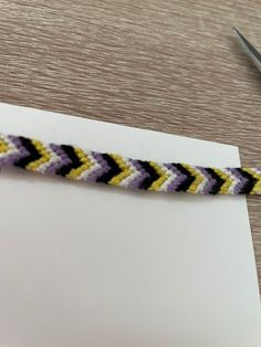 a close up of a piece of string with scissors on the table next to it