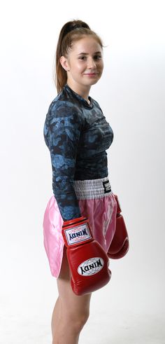 a young woman wearing red boxing gloves and a blue shirt is posing for the camera