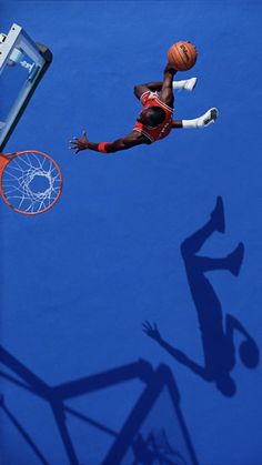 a basketball player is in mid air after dunking the ball into the hoop with his feet