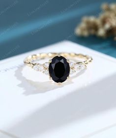 a black diamond ring sitting on top of a white box