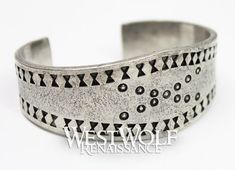 This beautiful Viking bracelet is historically accurate and modeled after a silver Viking bracelet found in the Curedale hoard at Lancashire, England in 1840. This type of stamped design was common in Viking culture, and solid silver bracelets such as this would have been used both as bullion and as jewelry. This particular bracelet we offer has been handmade of finely polished silver pewter and recreated from the archaeological find in every detail. The metal of this bracelet is completely safe Viking Style Silver Bangle Bracelet, Medieval Style Silver Bracelet Gift, Hand Forged Silver Viking Jewelry, Medieval Engraved Bracelet Jewelry, Silver Viking Bracelet Engraved, Vintage Silver Jewelry For Costume Or Role-play, Medieval Norway, Lancashire England, Solid Silver Bracelets