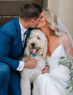 a bride and groom kissing with their dog