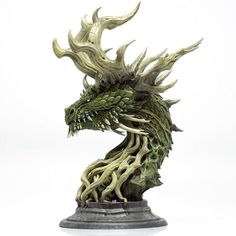 a statue of a green dragon head on a white background with no one around it