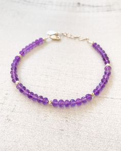 February's birthstone shimmers in this handcrafted beaded bracelet. Beautifully faceted amethyst gems are accented with bright sterling silver beads. An extender chain allows for an adjustable fit. Bracelet length: 7.25 inches plus 1-inch extender Materials: amethyst beads, sterling silver components Purple Rondelle Beaded Bracelets As Gift, Sterling Silver Rondelle Gemstone Beaded Bracelets, Elegant Lavender Beaded Bracelets With Faceted Beads, Elegant Lavender Bracelets With Faceted Beads, Elegant Purple Crystal Bracelet With Spacer Beads, Elegant Lavender Beaded Bracelets With Gemstone, Elegant Lavender Beaded Bracelet With Faceted Beads, Elegant Lavender Gemstone Beaded Bracelets, Elegant Purple Crystal Bracelet For Healing