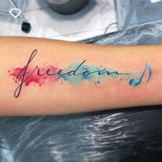 a watercolor tattoo with the word freedom written in cursive writing