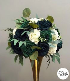 a gold vase filled with green and white flowers