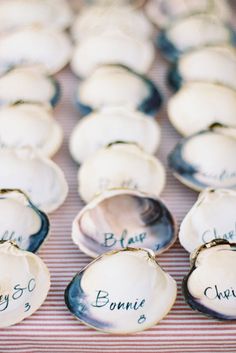 shells with names on them sitting on a red and white striped tableclothed cloth