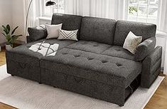 a living room scene with focus on the grey couch and white area rugs,