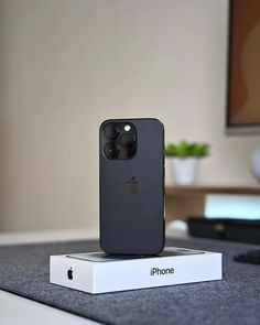 an iphone sitting on top of a white box