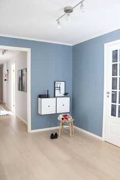 a living room with blue walls and white furniture