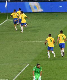 the soccer players are running around on the field in their green and yellow uniforms,