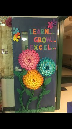 a classroom door decorated with flowers and the words learn grow excel