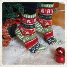 a pair of christmas socks sitting on top of a white rug