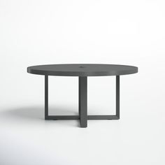 a round table with metal legs and a grey top, on a white background in an empty room