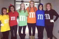 four women in matching m and m shirts pose for a photo together with their hands on their hipss