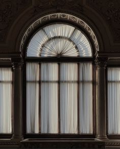 the sun shines through an arched window in a room with ornate carvings and columns