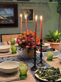 a dining room table set with plates and candles