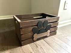 a wooden crate with a dog's paw and name engraved on the front side