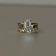 an emerald cut diamond engagement ring set in yellow gold with baguettes on each side