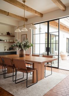 a dining room table with chairs and a vase on it