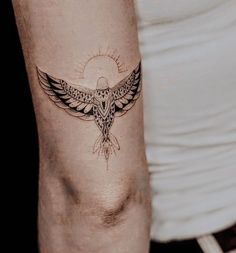 a tattoo on the arm of a person with a bird and sun in the background